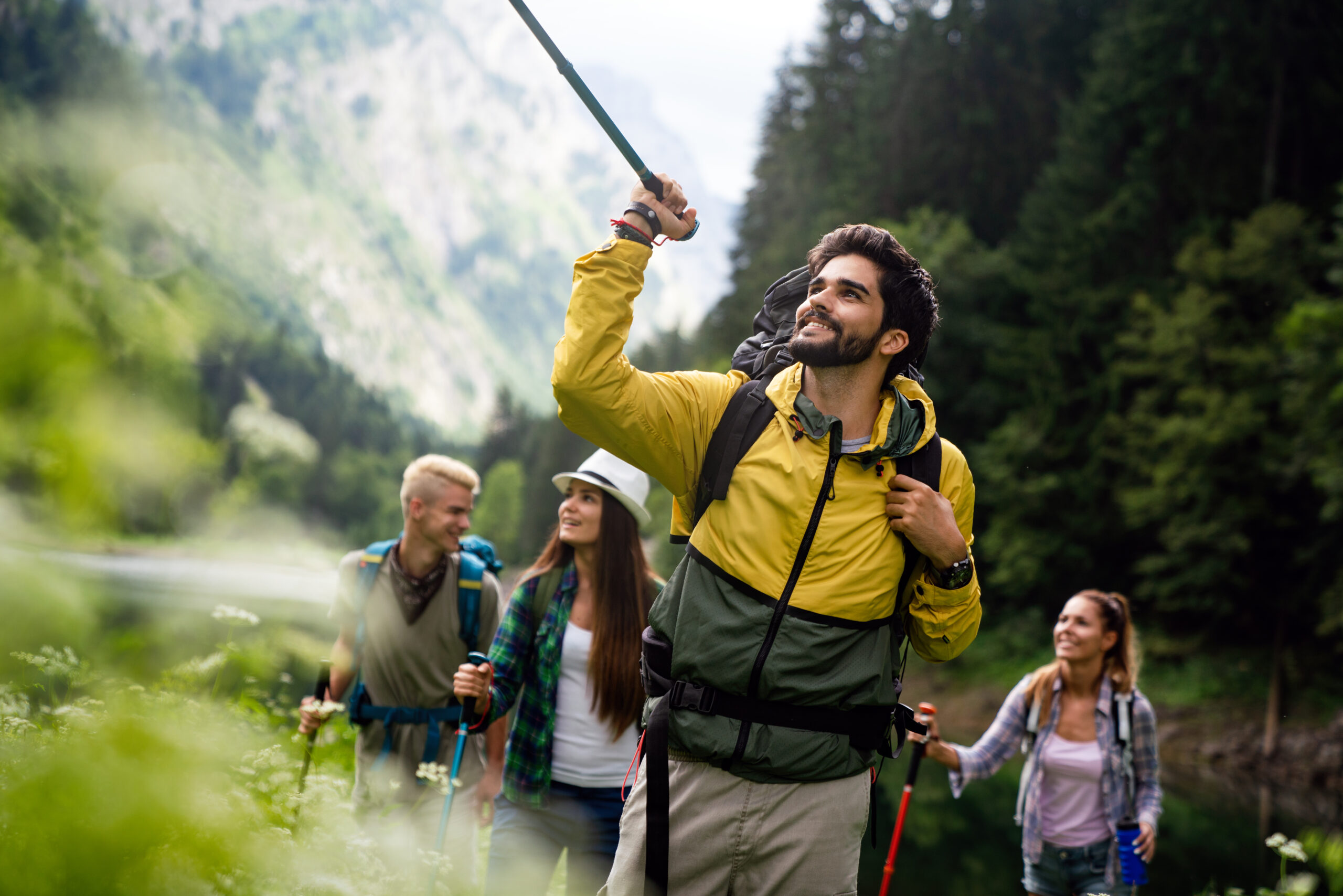 Group of happy fit young friends hiking, trekking together outdoor nature